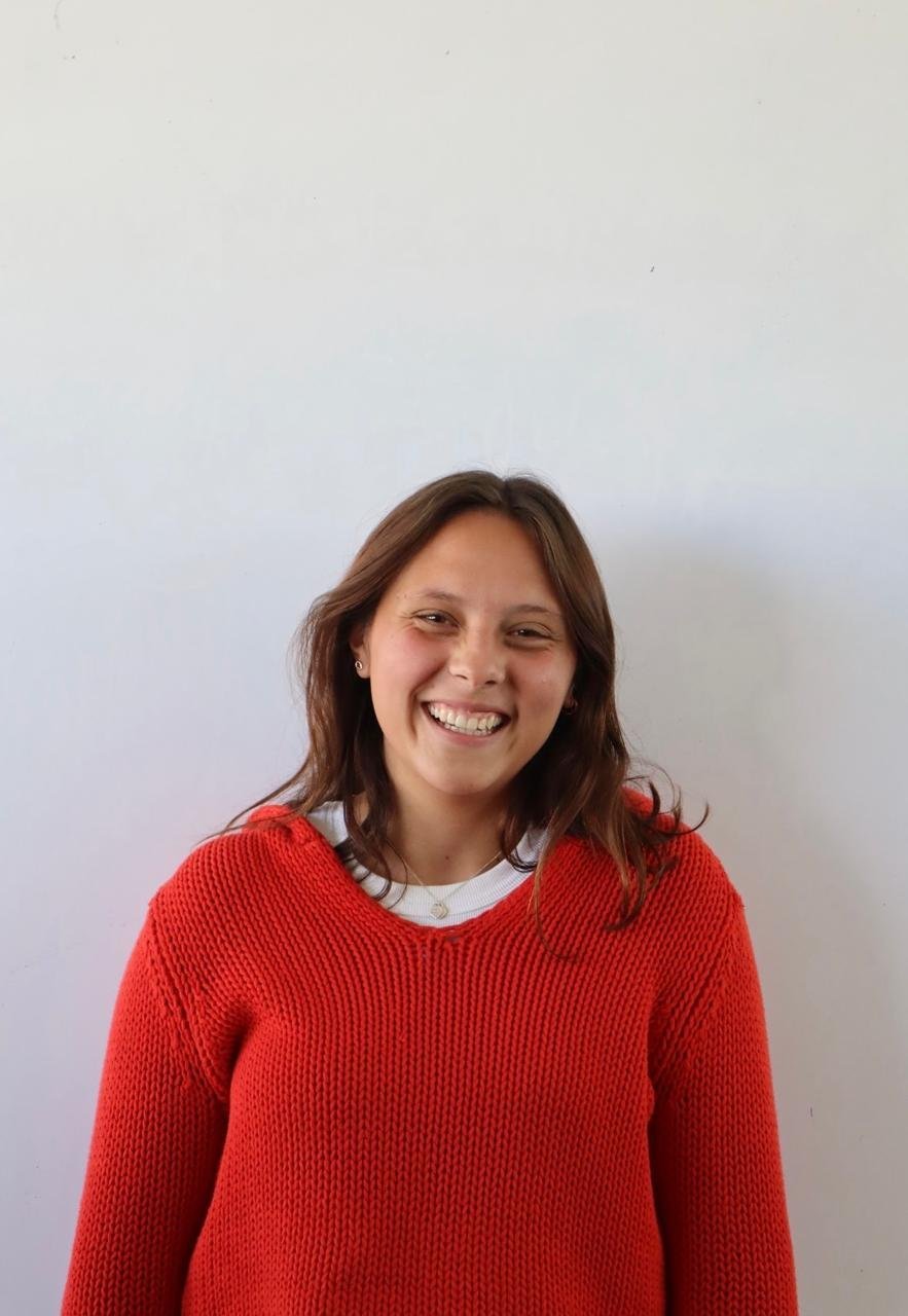 Martina Muñoz, guía de Sientecalma, sonriendo con suéter rojo de punto